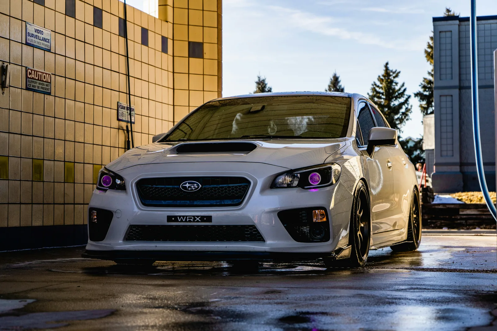 Yellow Subaru WRX parked in a workshop-style setting